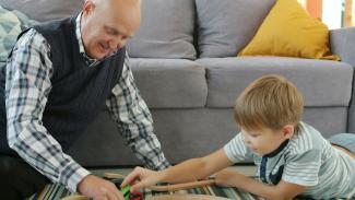 Grandfather and grandson playing with toy train
