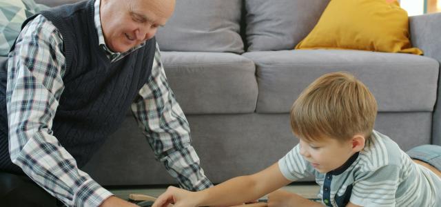 Grandfather and grandson playing with toy train